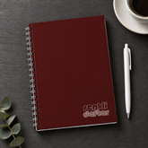 Bordo defter A5 yandan spiralli sert kapak, beyaz kalem hediyeli, antrasit masa üzerinde